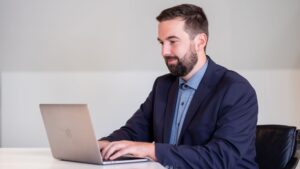 Ein Versicherungsmakler beim Arbeiten am Laptop