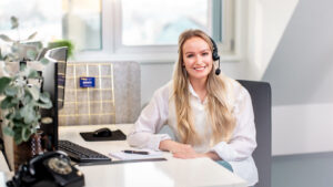 Eine Sekretärin die lächelnd telefoniert