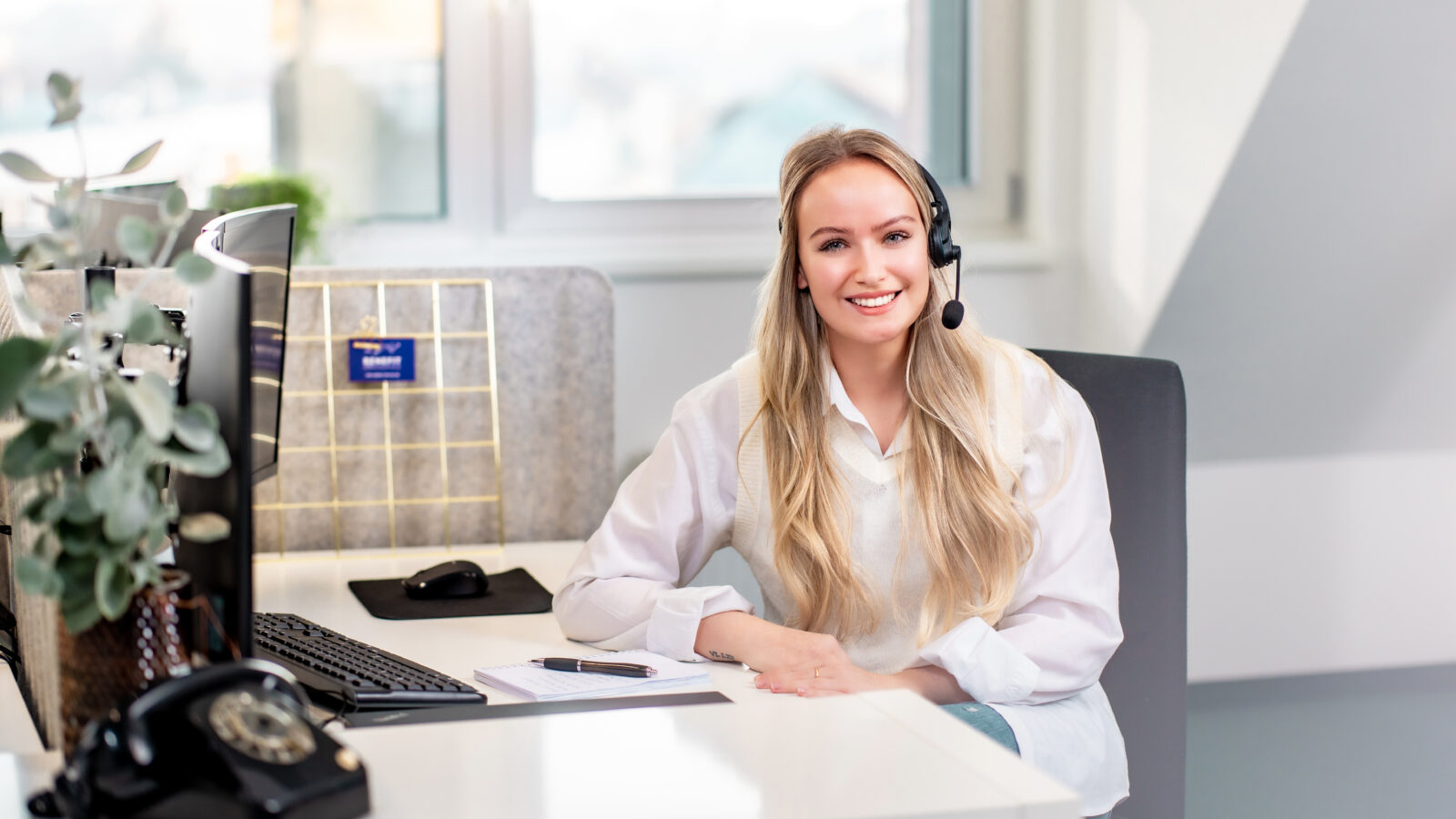 Eine Sekretärin die lächelnd telefoniert