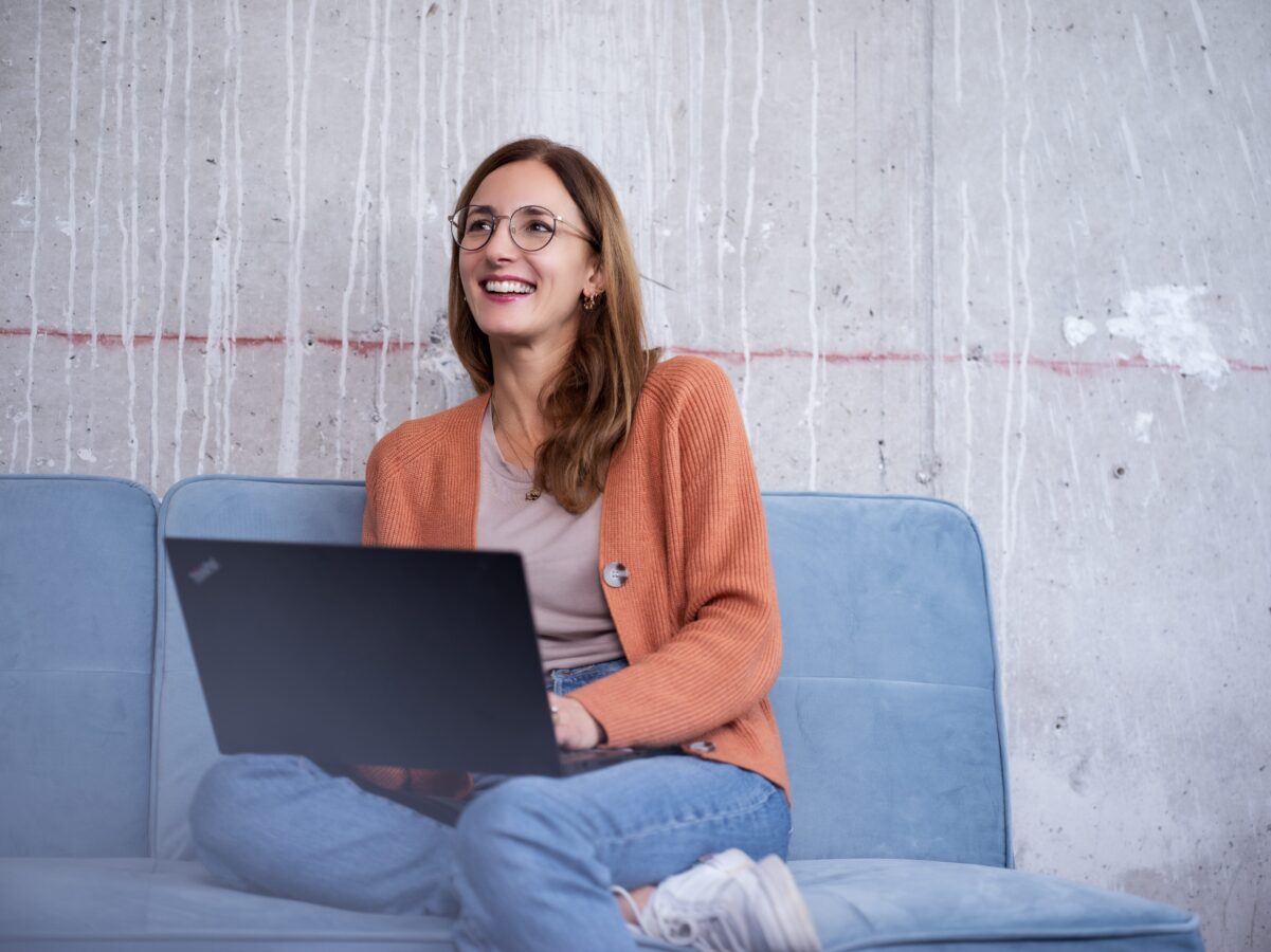 Frau sitzt glücklich vor dem Laptop
