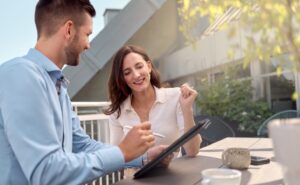 Mann zeigt Frau etwas am Tablet